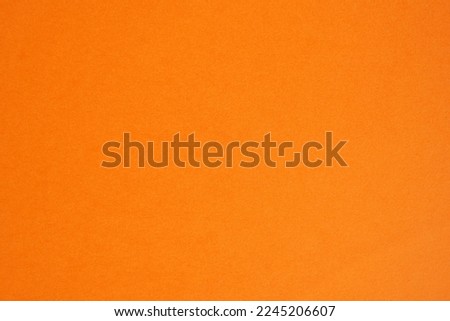 Closeup photo of cardboard sheet surface in orange color. Unicolor background.