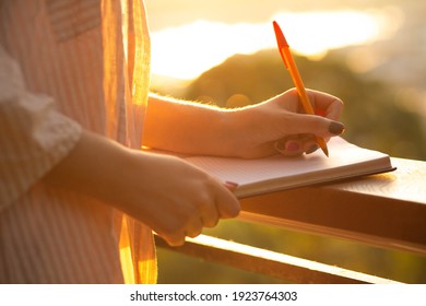 Closeup photo of a casual dressed freelancer woman writing in notepad outdoor in the morning. Space for text - Shutterstock ID 1923764303