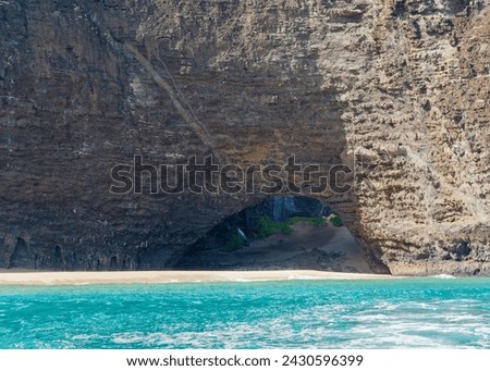 Close-up photo of an cave entrance in the cliff at the Napali Coast State Wilderness Park, Island of Kauai, Hawaii