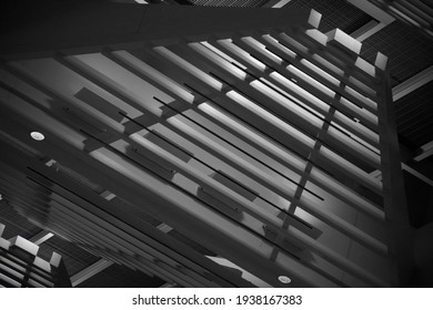 Close-up photo of ceiling fragment. Abstract architecture and technology detail. Modern interior design with linear elements. Geometric structure of girders, panels and parallel lines.