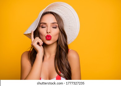 Closeup photo of charming lady long hairdo bronze body skin sensual plump lips send sincere air kisses wear sun headwear white red striped bodysuit isolated bright yellow color background