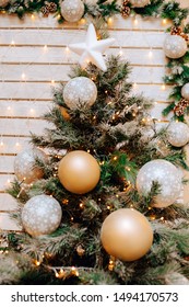 Close-up photo of christmas festive decoration with candles, white golden balls and christmas tree.