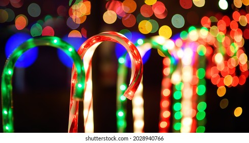 Close-up photo of Christmas and New Year decorations. Fence decorated with a garland like multicolored candy stick cane. Stylish outdoor Xmas decorations - Powered by Shutterstock