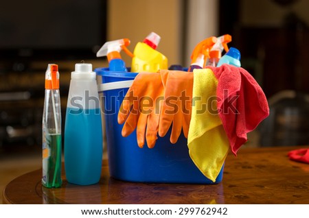 Closeup photo of cleaning chemicals, gloves and rags lying in plastic bucket