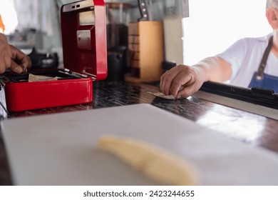 Close-up photo of a customer paying from the window of a food truck - Powered by Shutterstock