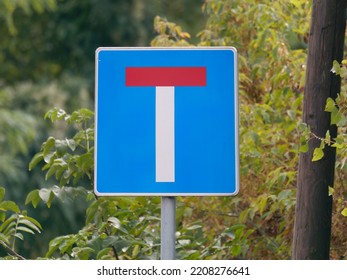 Close-up Photo Of A Dead End Road Sign On A Metal Pole With Trees In The Background