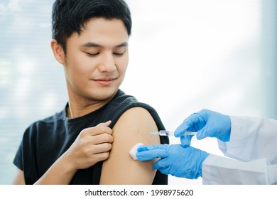 Close-up photo of doctor giving vaccine against COVID-19 or influenza virus to Asian patients. An Asian man was vaccinated during a vaccination campaign. - Powered by Shutterstock