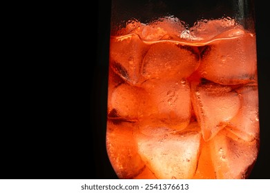 Close-up photo of a fancy glass full with ice and red cocktail drink on a dark background with copy space. - Powered by Shutterstock