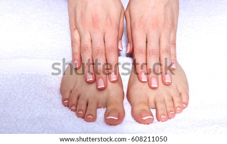 Closeup photo of female feet and hands with pedicure and manicure