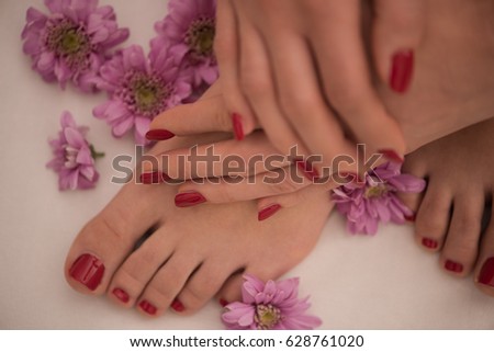 Closeup photo of a female feet and hands at spa salon on pedicure and manicure procedure