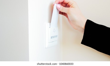 Closeup Photo Of Female Hand Insert Key Card In Holder On Hotel Room Wall