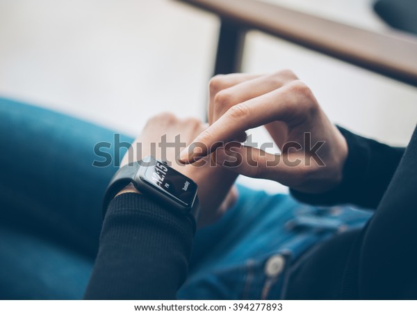 Closeup\
photo of female hand touching screen generic design smart watch.\
Film effects, blurred background.\
Horizontal