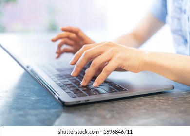 Close-up photo of female hands typing on keyboard at indoor workplace - Shutterstock ID 1696846711