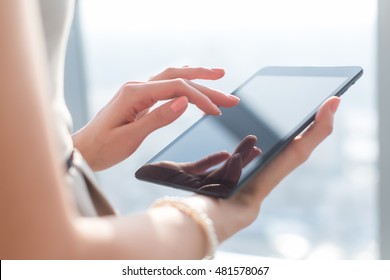 Close-up photo of female hands working with tablet computer. Woman using social network, texting and blogging. - Powered by Shutterstock