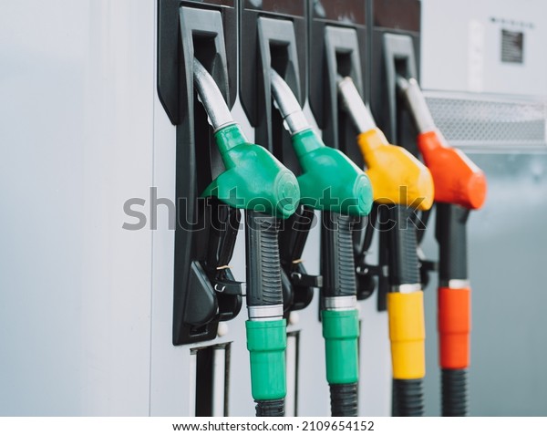 Close-up photo of filling nozzles in\
different colors at a gasoline and diesel fuel\
station