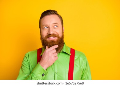 Closeup Photo Of Funny Red Head Guy Look Side Empty Space Thinking About Crazy Trick Arm On Chin Wear Green Shirt Red Suspenders Isolated Vibrant Color Background