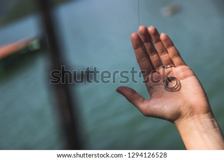 Close-up photo of girl's hand showing her fishing catch, silver earrings