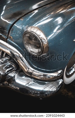 Close-up photo of headlights of an old blue classic car