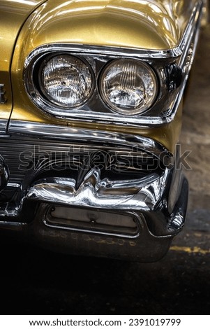 Close-up photo of headlights of an old yellow classic car