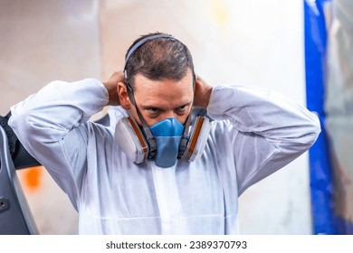 Close-up photo of an industrial painter putting on protective gear for work - Powered by Shutterstock