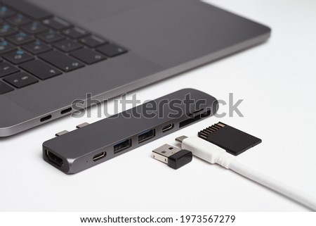 Close-up photo of laptop, type-c hub with cable and usb receiver. Minimalistic