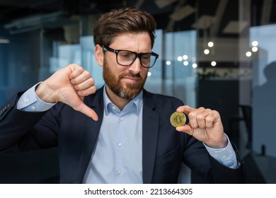 Close-up Photo Of Male Businessman Holding Gold Crypto Currency Bitcoin Coin In Hands, Mature Investor Disappointed With Money Rate And Investment, Boss In Business Suit Showing Finger Down