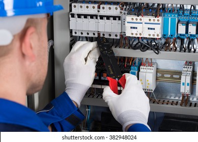 Close-up Photo Of Male Electrician Repairing Fusebox