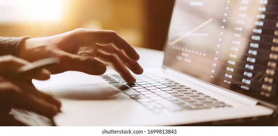 Close-up photo of male hands with laptop. Man is working remotely at home. Distance job - Shutterstock ID 1699813843