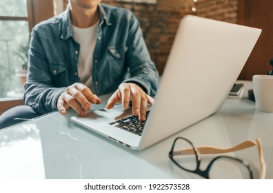 Close-up Photo Of Male Hands With Laptop. Man Is Working Remotely From Home. Freelancer At Work