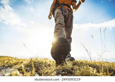 Close-up photo of male legs in trekking boots walking on a hiking trail - Happy hiker climbing mountains - Travel and sport life style concept  - Powered by Shutterstock