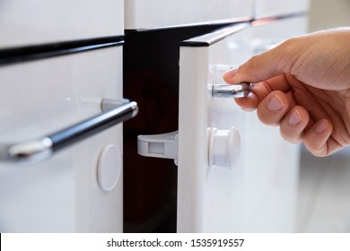 Close-up Photo Of Man Opening Child Proof Kitchen Cabinets