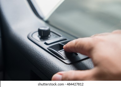Closeup photo of man pressing button controlling window in car - Shutterstock ID 484427812