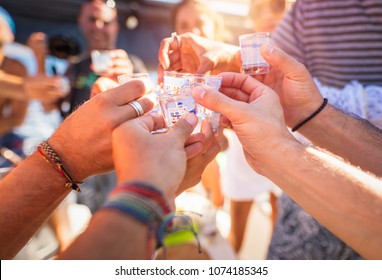 Closeup photo of a men hands with glass full of alcoholic drink, speaking toast, cheers, celebrating holiday, open air party, happy summer vacation