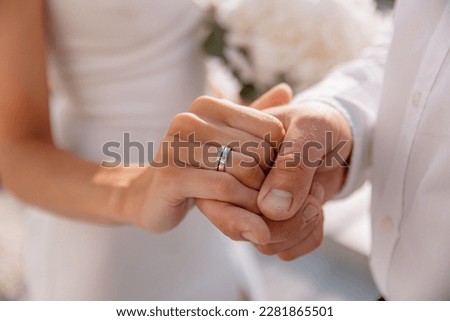 Close-up photo of the men`s holding woman hand with golden wedding ring with diamond. Wedding ring before the proposal. Luxury wedding rings
