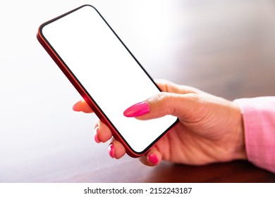 Closeup photo of mobile phone in woman's hand, white empty screen mockup - Powered by Shutterstock