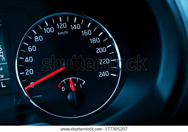 Closeup\
photo of modern automotive speedometer on black\
