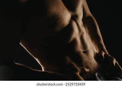 Close-up photo of a muscular male torso showcasing abdominal muscles, highlighting fitness and strength. - Powered by Shutterstock