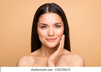 Closeup photo of naked latin lady model natural beauty without makeup touch cheek pure soft smooth skin applying anti age cream isolated beige pastel color background