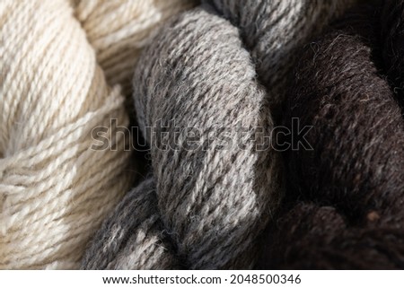 Close-up photo of off-white, grey and black wool yarn