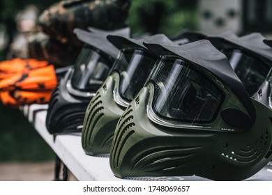Closeup Photo of Paintball Gear Before Training At The Shooting Range. Protective Camouflage Mask at Table. Special protective mask for playing paintball