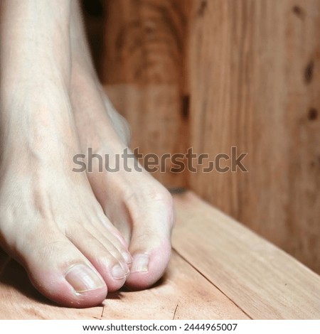 Closeup photo of pair of bare feet with wooden background
