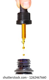Closeup photo of person dispensing drops of healthy herbal medicinal marijuana CBD oil