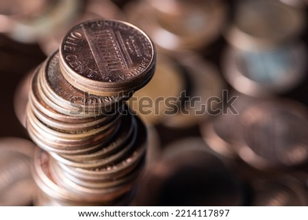 Closeup photo of a pile of 1 cent dollar coins with more coins in the background