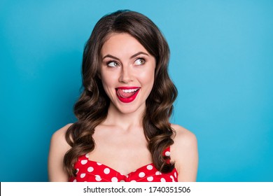 Closeup photo of pretty funny wavy lady licking plump tempting lips look side empty space dream of yummy tasty dinner wear red dotted dress singlet isolated blue color background