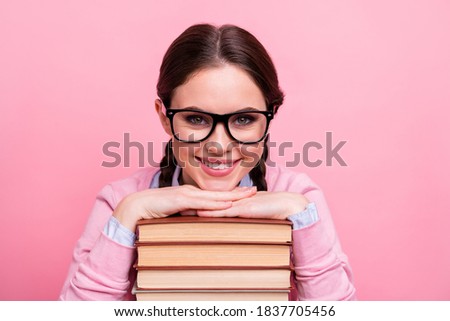 Closeup photo of pretty student lady two braids leaning hands head books pile diligent pupil visit library fond of reading wear shirt pullover specs isolated pastel pink color background
