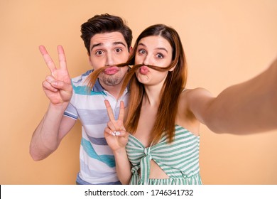 Closeup photo of pretty wife lady husband guy crazy childish couple spend time take selfies show v-sign making fake mustache curls wear casual clothes isolated beige color background