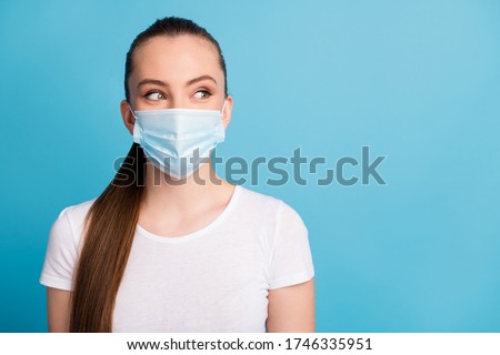 Closeup photo of pretty young lady look side empty space keep social distance not contacting people funny expression wear protect face medical mask white t-shirt isolated blue color background