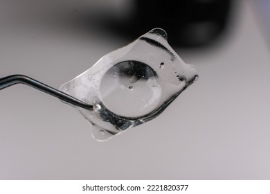 closeup photo of real eye lens removed from human suffering from cataract beside intra ocular lens - Shutterstock ID 2221820377