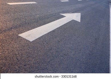 Closeup Photo Of The Road With White Arrow.