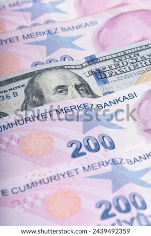 A close-up photo of a row of Turkish money with a US $100 bill in the middle, partially visible.